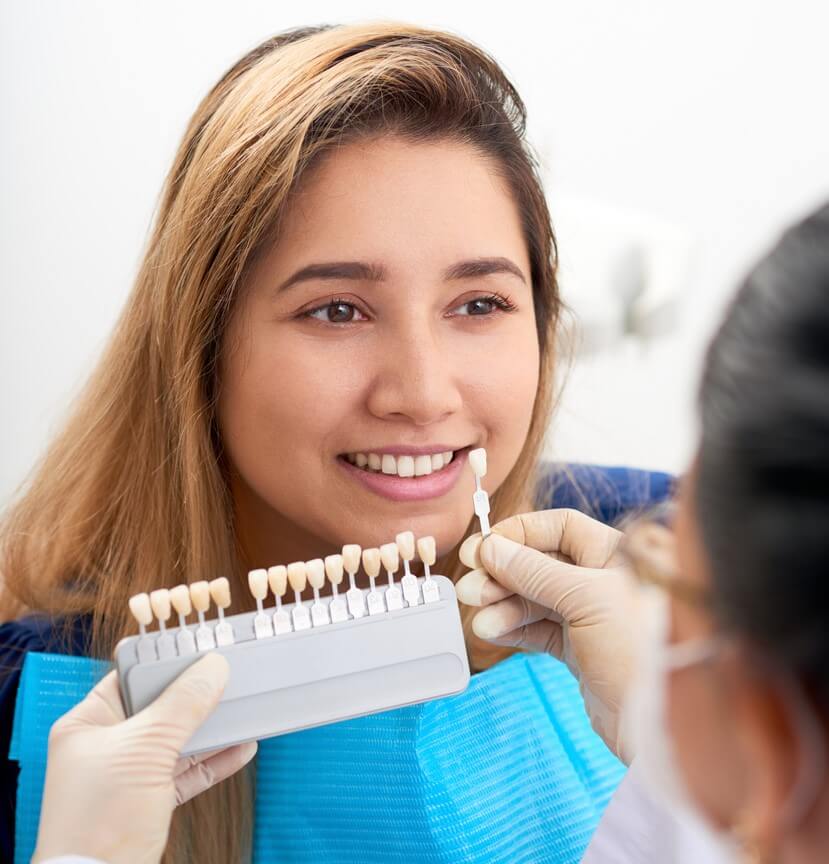 Dentist Picking Shade Of veneers For Patient To Improve Smile